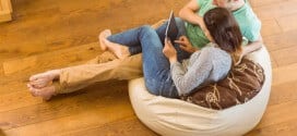 Cute couple using tablet pc on beanbag